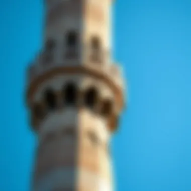 A close-up view of a traditional mosque minaret against a blue sky