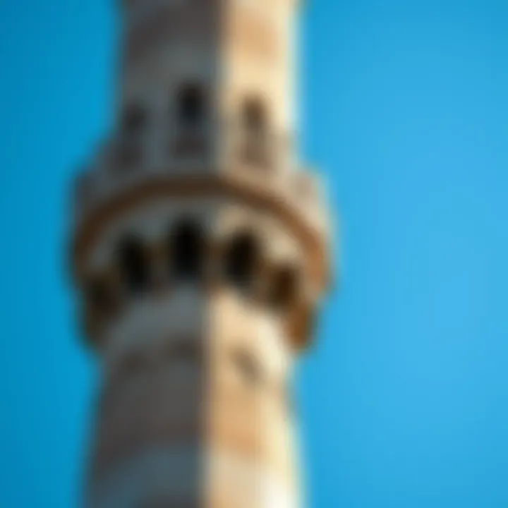 A close-up view of a traditional mosque minaret against a blue sky